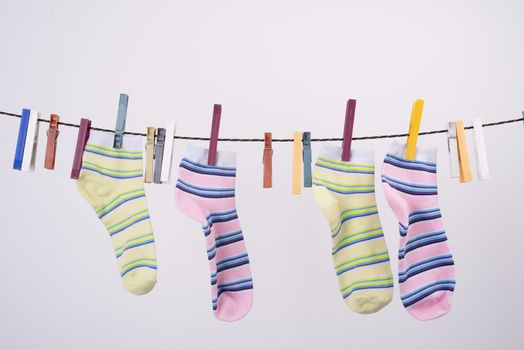 two socks hanging on a thread to dry