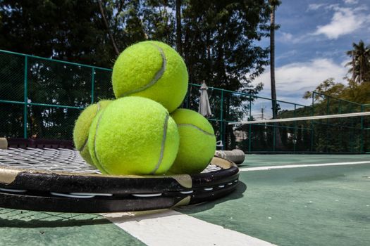 Tennis balls and racket in tennis court outdoors