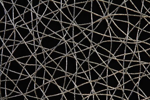 Chaotic weave of silver threads on black, abstract background