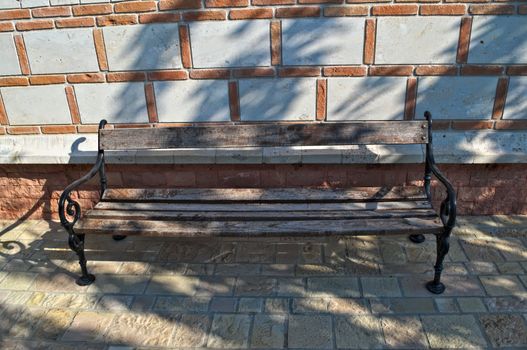 Wooden bench in front of bricks wall