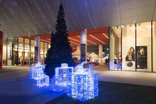 bright Christmas recourse lit up in front of a shopping mall