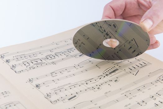 A page of a musical score with a CD on hand