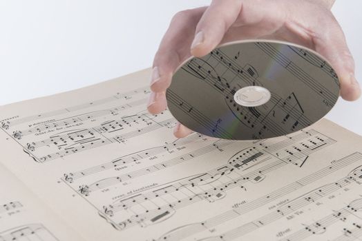 A page of a musical score with a CD on hand