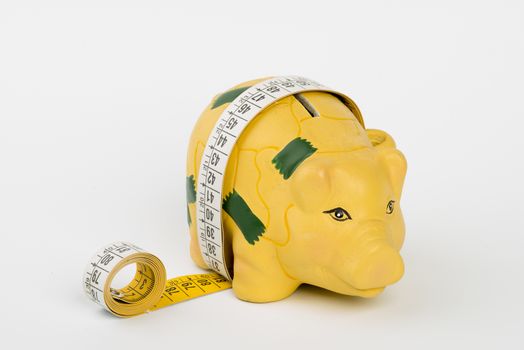 a piggy bank wrapped by a tape measure