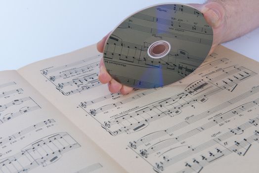 A page of a musical score with a CD on hand