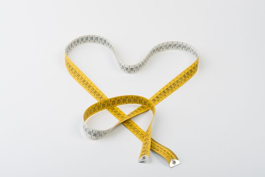 a heart formed with a yellow tape measure