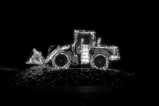 Blurred wheel loader decorated with lights bokeh