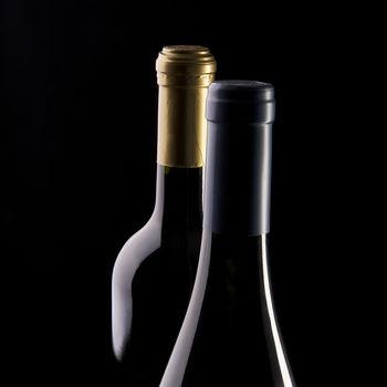 two bottles of wine with a black background