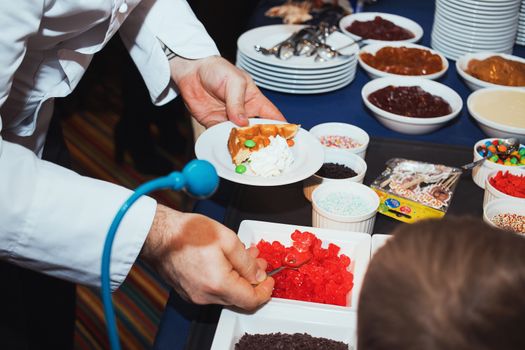 Male chef decorating tasty dessert in kitchen