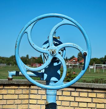 Blue wheel on water well pump, close up