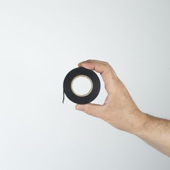 a roll of insulating tape in his hand