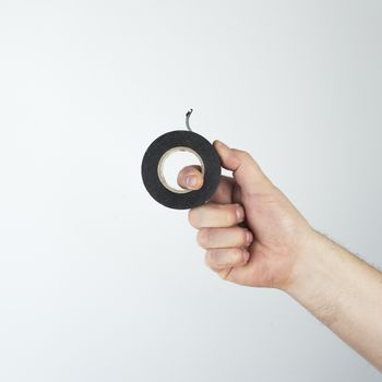 a roll of black insulating tape in his hand