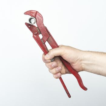 a wrench tighten pipe in hand