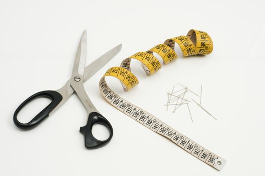 piece of fabric with scissors, pins and tape measure