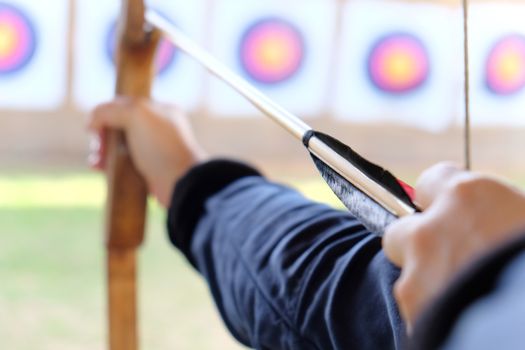 Archer holds his bow aiming at a target
