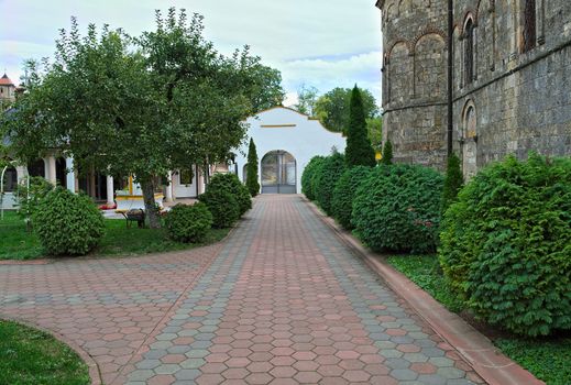 Red bricks sidewalk leading to gate in Serbian monastery