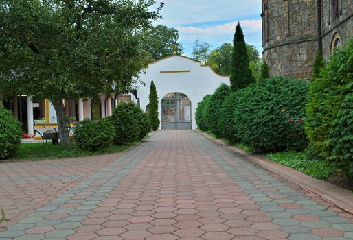 Red bricks sidewalk leading to gate in Serbian monastery