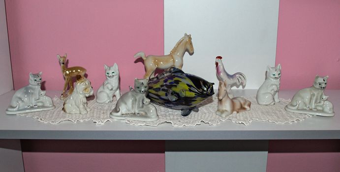 Ceramic figurines of animals sitting on shelf