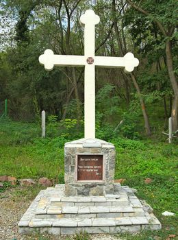 Stone cross monument, orthodox christian, in park