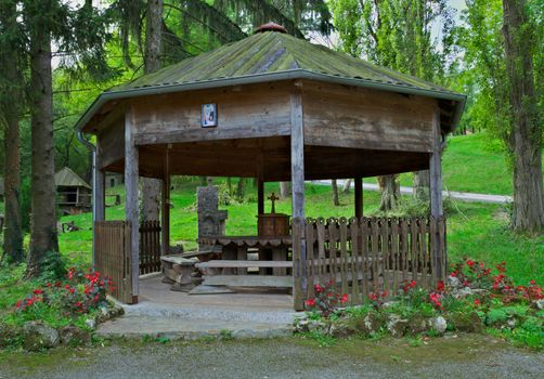 Wooden open hut with table and benches for relaxing in park