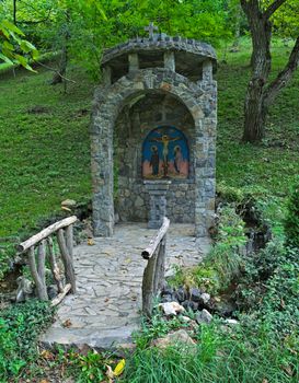 Small decorated stone christian monument in park