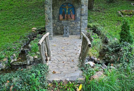 Small decorated stone christian monument in park