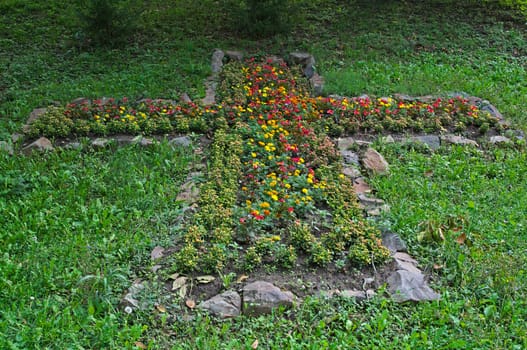 Cross made out of flowers and rocks in etno park