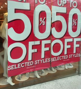 Sale sign banner hanging in shop front window for Christmas Boxing Day sales