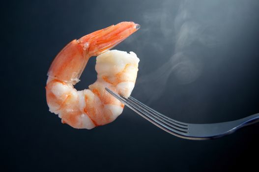 Steaming hot shrimp on a fork closeup