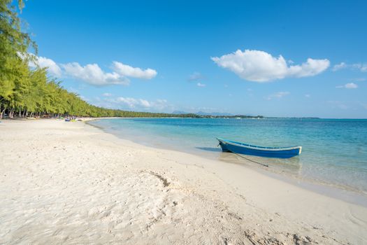 Fish boat on blue sea and  paradice beach  with white sand at Mauritius island.