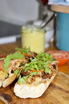 Delicious sandwich on the wooden board in the kitchen.