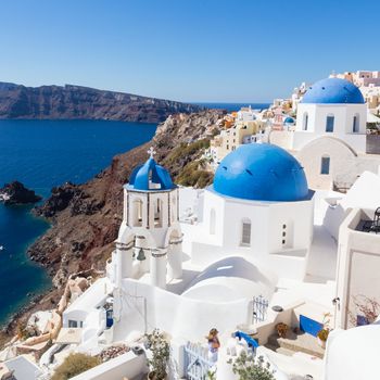 Cityscape of Oia, traditional greek village with blue domes of churches, Santorini island, Greece.