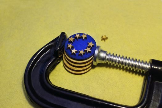 euro coin in the clamp  pressure after brexit, conceptual image crisis of the European Union