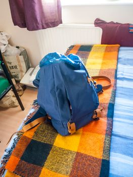 blue backpack rucksack on bed close up student; essex; england; uk