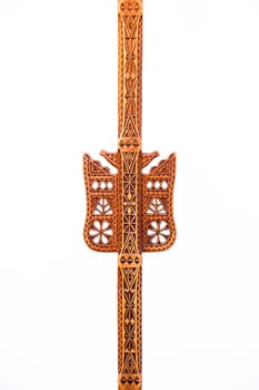A hand-made work of art of an folk artisan carved decoration in a single piece of wood with geometric shapes and symbols for bird, flower, snake and pine-tree