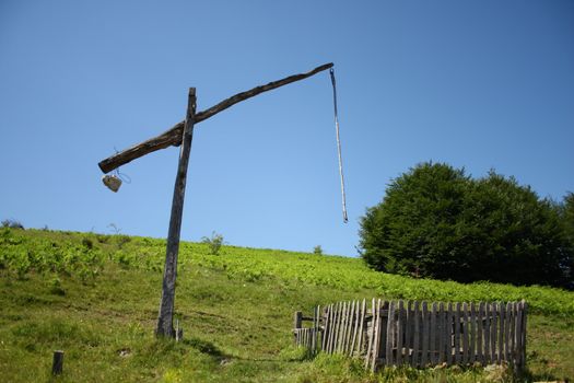 A very old wooden water well with a counterweight system based on stones which is missing the bucket