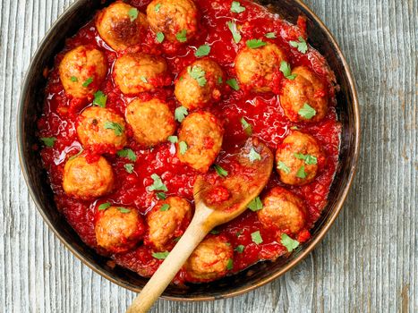 close up of rustic italian meatball in tomato sauce