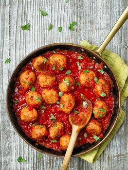 close up of rustic italian meatball in tomato sauce