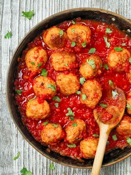 close up of rustic italian meatball in tomato sauce