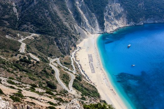 A view from above on the Myrtos Beach with boats on the sea and the road to the beach