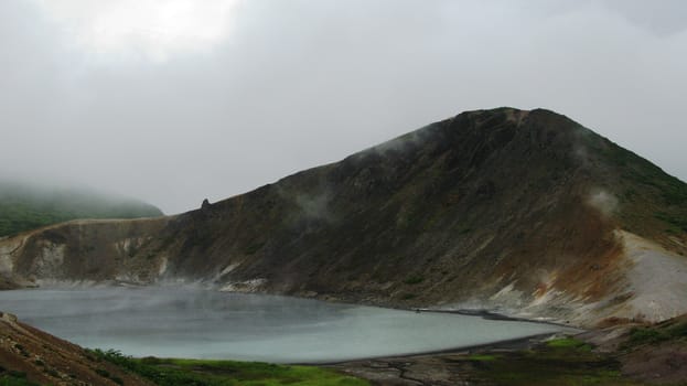 Steam lake in the crater of Golovnina volcano in Kunashir island, Kurily, Russia