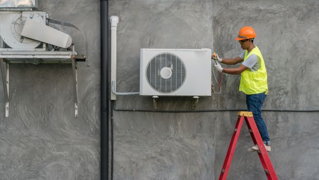 Technician is checking outdoor air conditioner unit