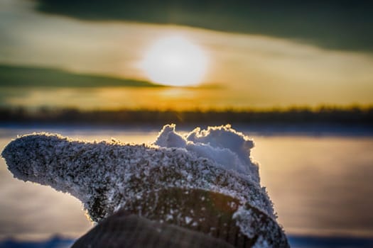 Hands with a beautiful sky winter sunset on the river