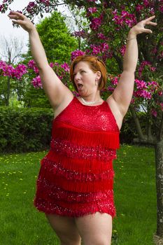 forty something woman in sparkly dress doing a flamboyant ladystyling move