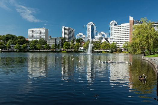 Cityscape of the modern buildings in Stavanger in front of the lake and fountain, Norway