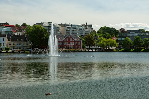 Cityscape of the old buildings in Stavanger in front of the lake and fountain, Norway