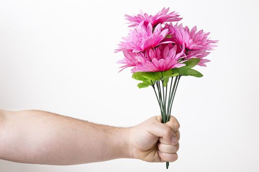 man arms holding a bouquet of pink fake flower