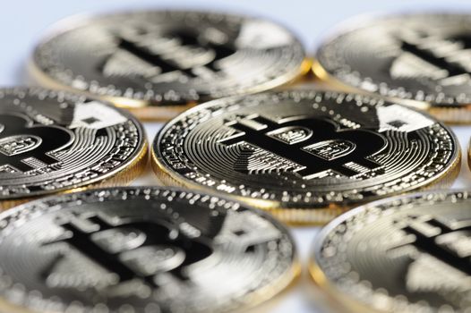 Macro view of shiny Bitcoin souvenire coins on light background, selective focus