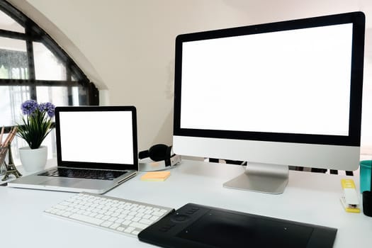 Laptop and computer pc desktop on work office table with empty screen display.