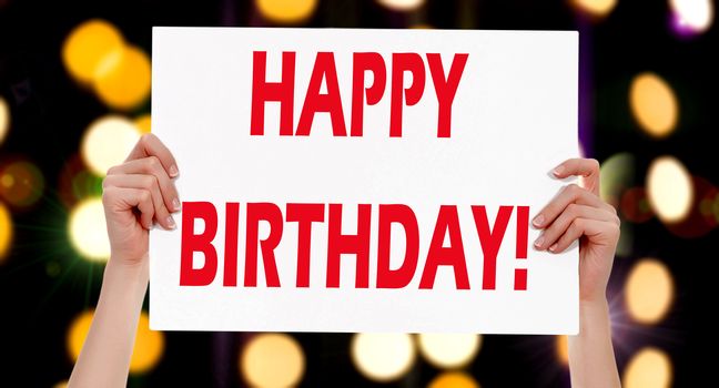 Happy Birthday! Female hands holding a placard with abstract lights bokeh background